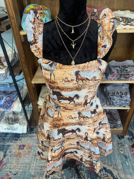 A fit-and-flare dress with a brown, beige, and black horse-print pattern, displayed on a black mannequin torso with gold necklaces in a retail store setting.